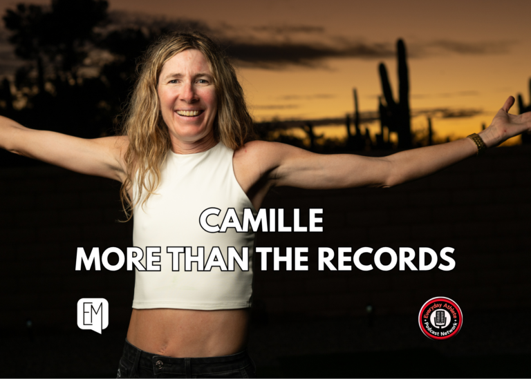 Camille Herron smiling with her arms outstretched in the Arizona desert at sunset.